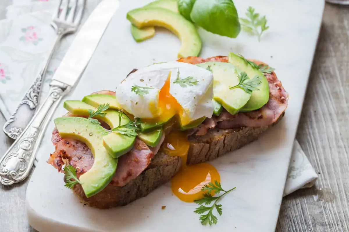 Avocado toast avec &oelig;uf poch&eacute;, bacon et avocat. Une recette simple et d&eacute;licieuse pour un brunch parfait.